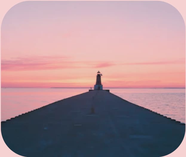 Lighthouse at pier during pink sunset